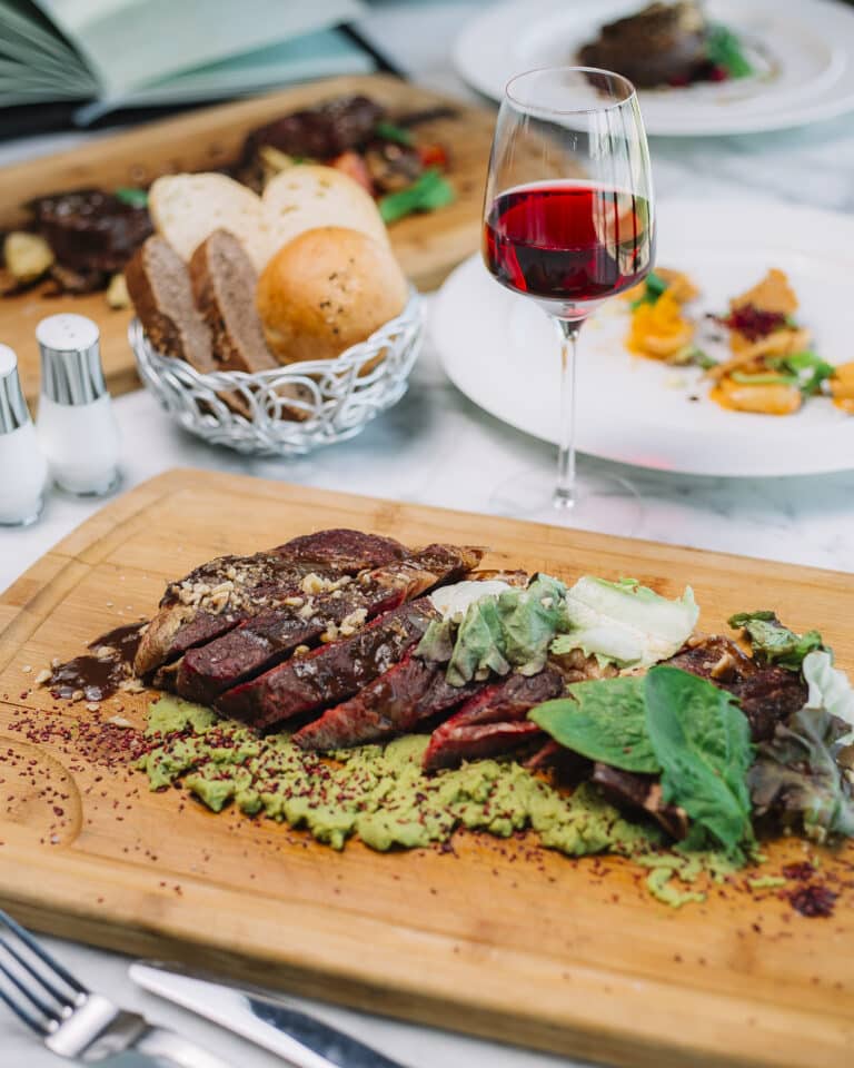 Tranches de steak saignant avec avocat écrasé noix laitue pinards